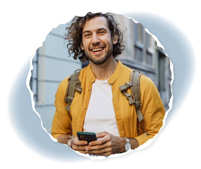 Ein Mann hält ein Smartphone in seinen Händen und lächelt in die Kamera.