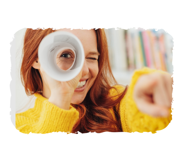 Junge Frau schaut durch eine Papierrolle in die Kamera. 