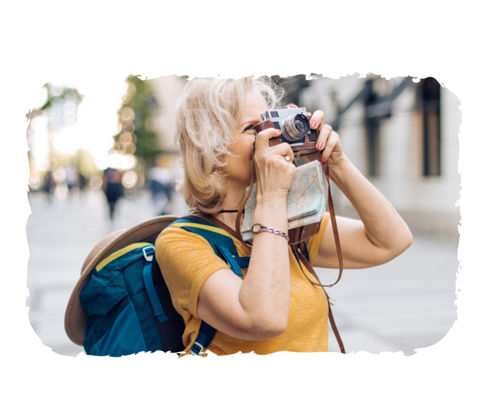 Eine ältere Frau blickt durch eine Kamera. 