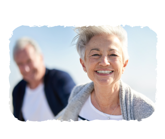 Eine älteren Frau und ein älterer Mann lächeln in die Kamera.