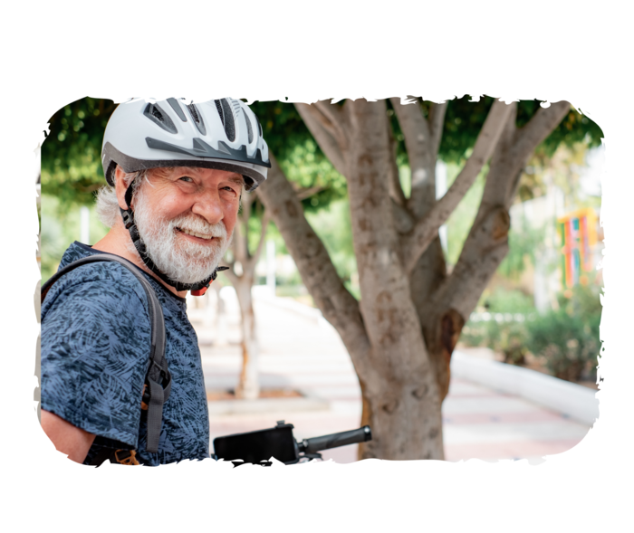 PV: Therapie Ein älterer Mann mit Fahrradhelm lächelt in die Kamera.