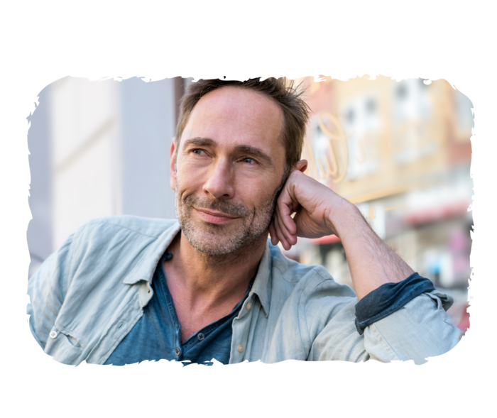 Ein Mann, der seinen Kopf in die Hand stützt und lächelt.