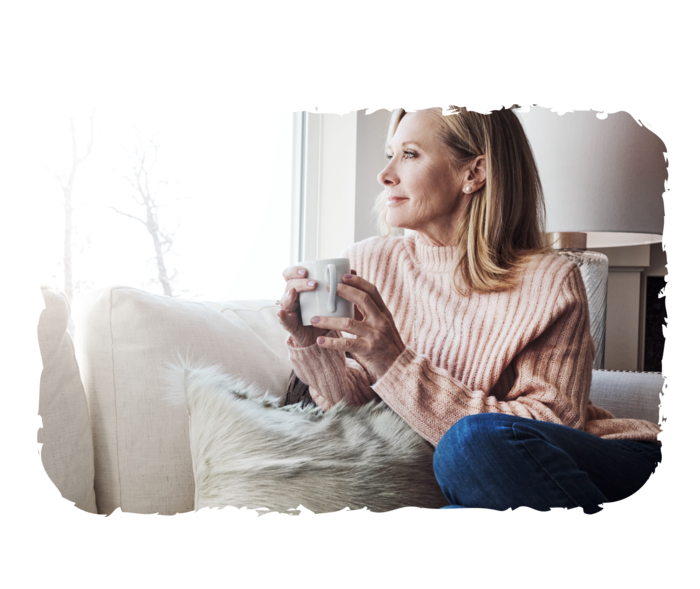 Eine ältere Frau schaut aus dem Fenster.