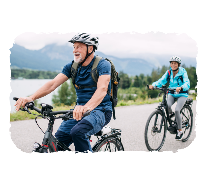 Ein älterer Mann und eine Person im Hintergrund fahren mit dem Rad.