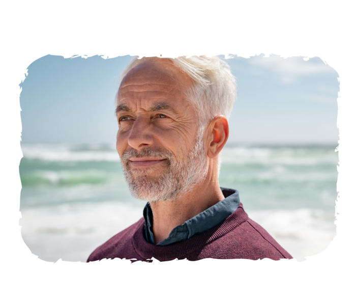 Ein älterer Mann blickt in die Ferne und lächelt.