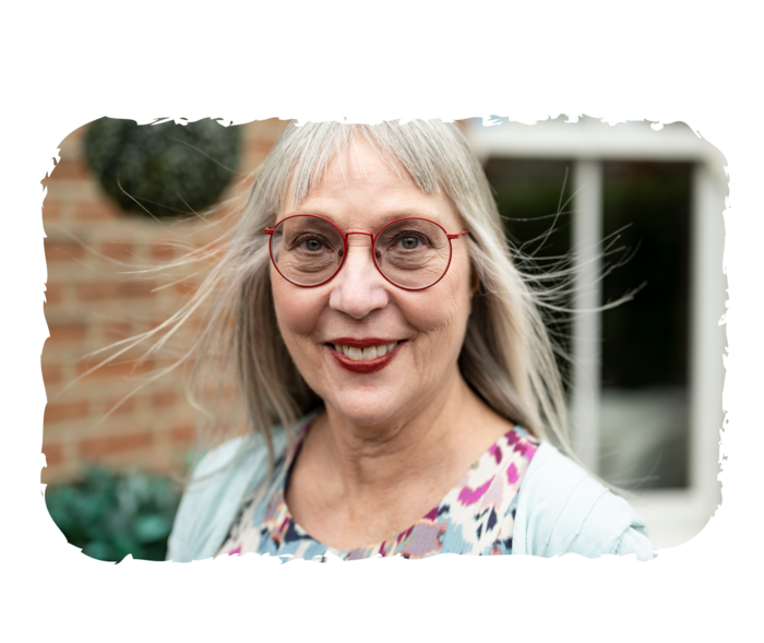 Eine ältere Frau lächelt in die Kamera.