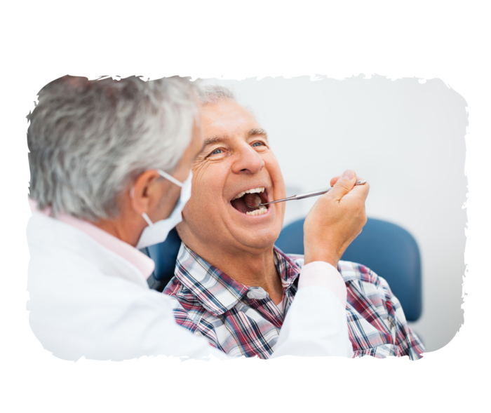 Ein Mann im weißen Kittel hält einen Mundspiegel an die Zähne eines älteren Mannes