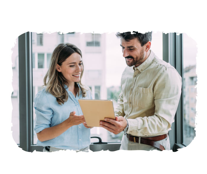 Ein Mann und eine Frau schauen auf eine Mappe in der Hand des Mannes.