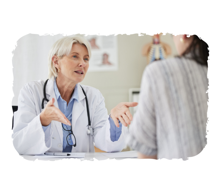 Eine Ärztin und eine weitere Frau sitzen sich gegenüber.