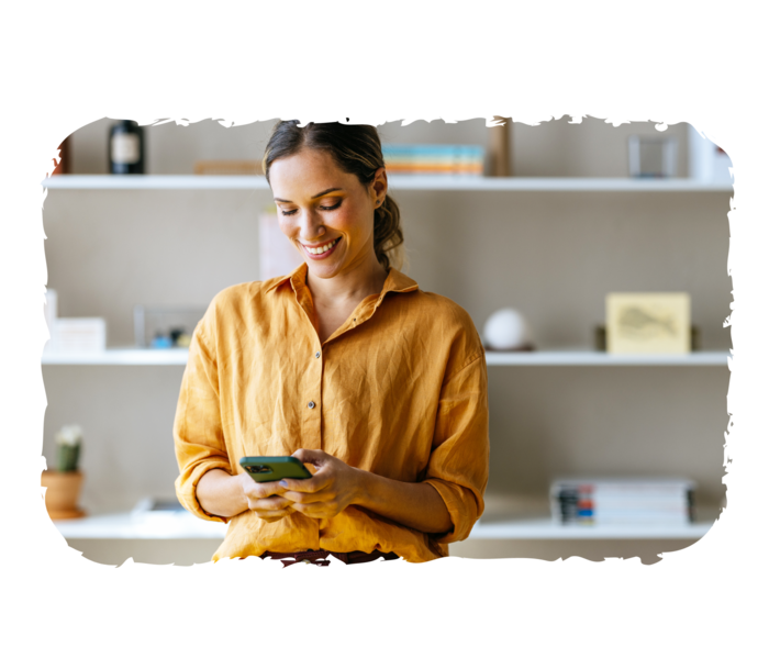 Eine Person hält ein Smartphone in der Hand und lächelt.