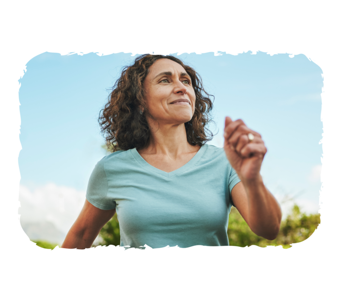 PNH: In Bewegung bleiben Lächelnde Frau, die ihre Arme am Körper vorbei schwingt. Im Hintergrund blauer Himmel.