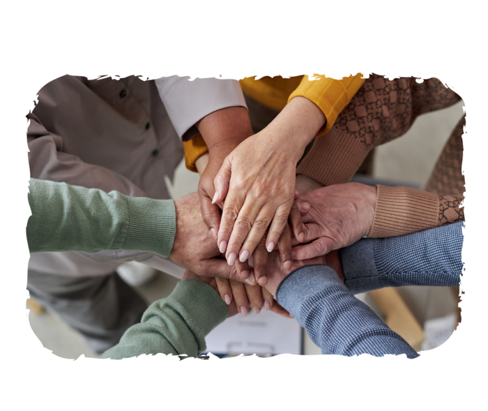 Mehrere Menschen legen ihre Hände aufeinander. Sichtbar sind nur die Hände.