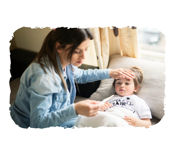 Eine Frau hält einem jungen Mädchen die Hand auf die Stirn und schaut auf ein Fieberthermometer in ihrer Hand.