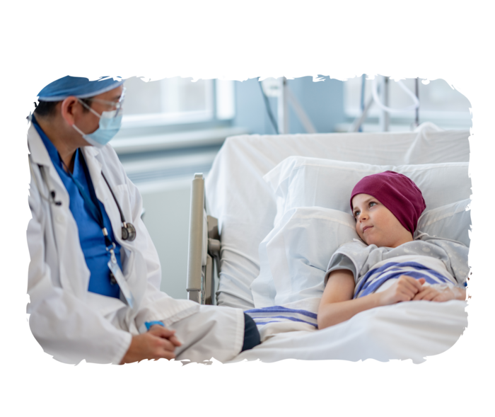 ALL: Therapie Ein Junge mit Kopftuch liegt in einem Krankenhausbett. Er schaut einen Arzt an, der neben ihm sitzt.