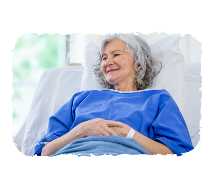 Eine ältere Person erhält eine Infusion und lächelt. 