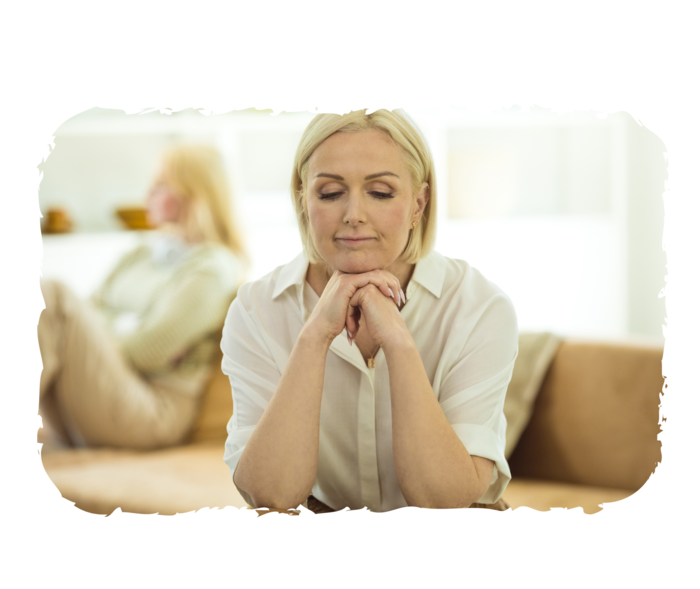 FL: Symptome Eine ältere Person sitzt auf dem Sofa und hält den Kopf in die Hänge gestützt.