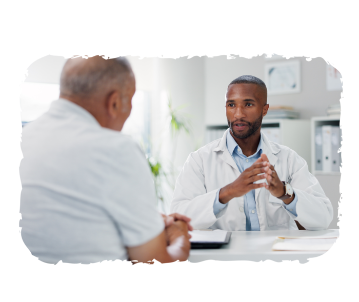Ein Arzt und ein älterer Mann sitzen sich gegenüber. 