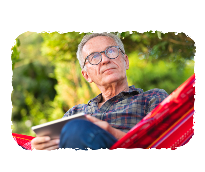 Ein älterer Mann sitzt in einer Hängematte.