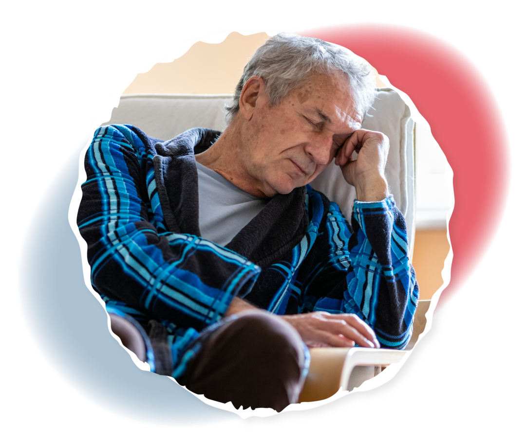 Ein älterer Mann sitzt auf einem Sessel und hat den Kopf in die Hand gestützt.