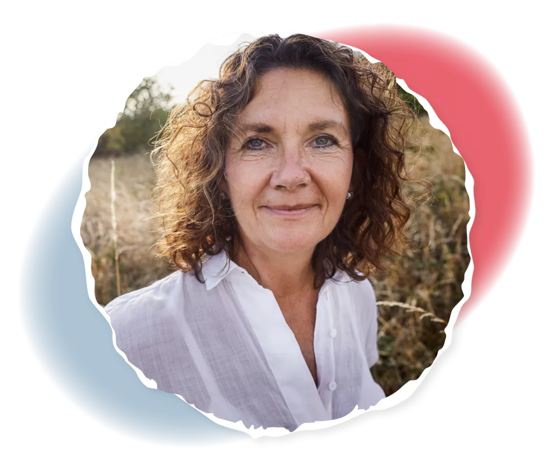 Eine ältere Frau lächelt in die Kamera. 