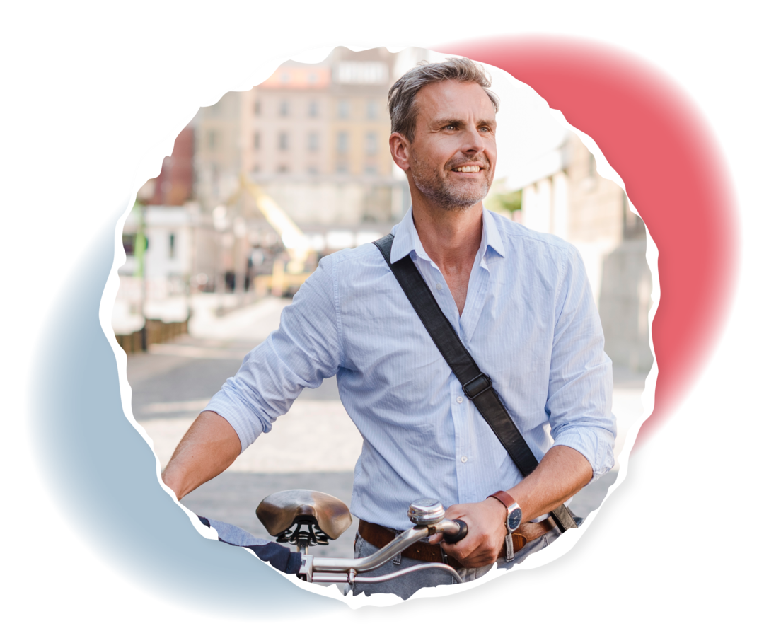 Ein Mann hält ein Fahrrad und lächelt.