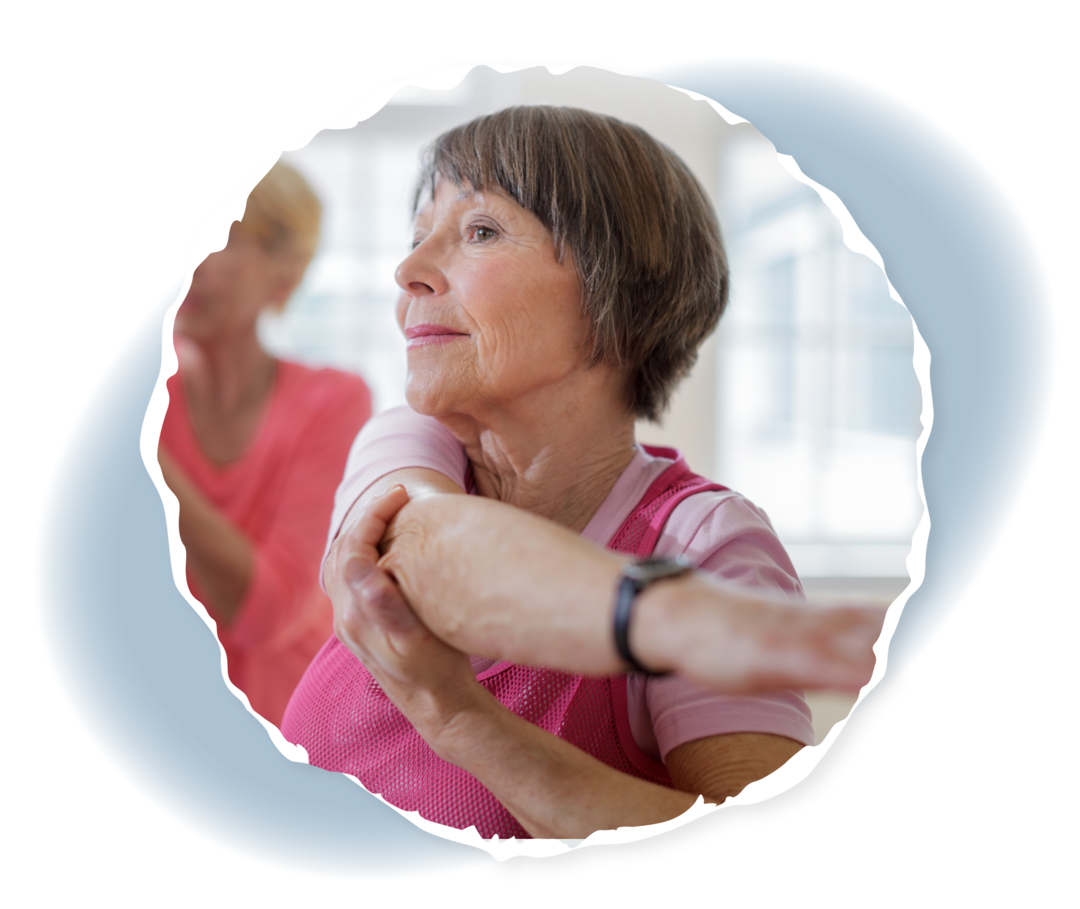 Ältere Frau dehnt ihren Arm.