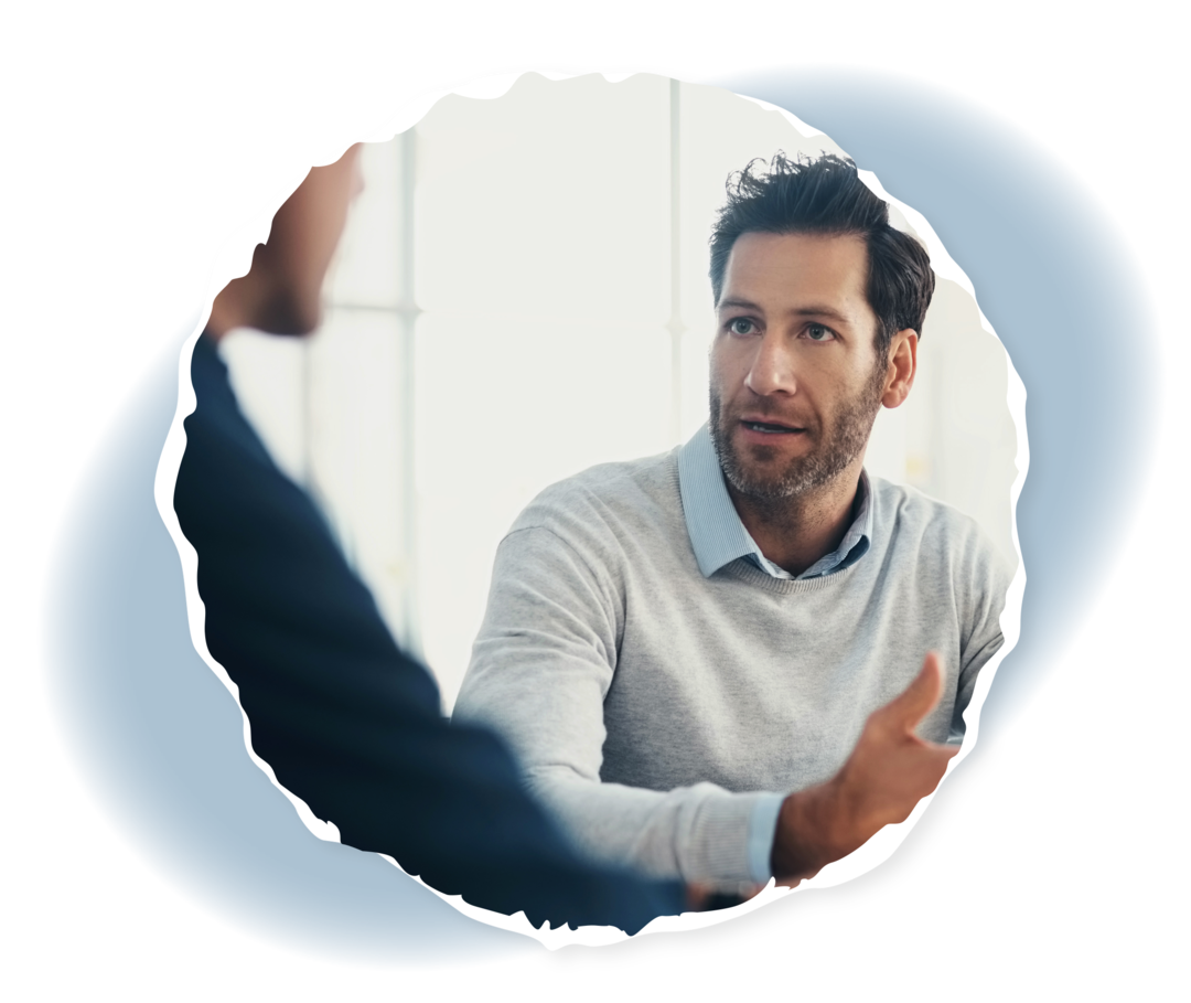 Zwei Männer sitzen an einem Tisch und sehen sich an.