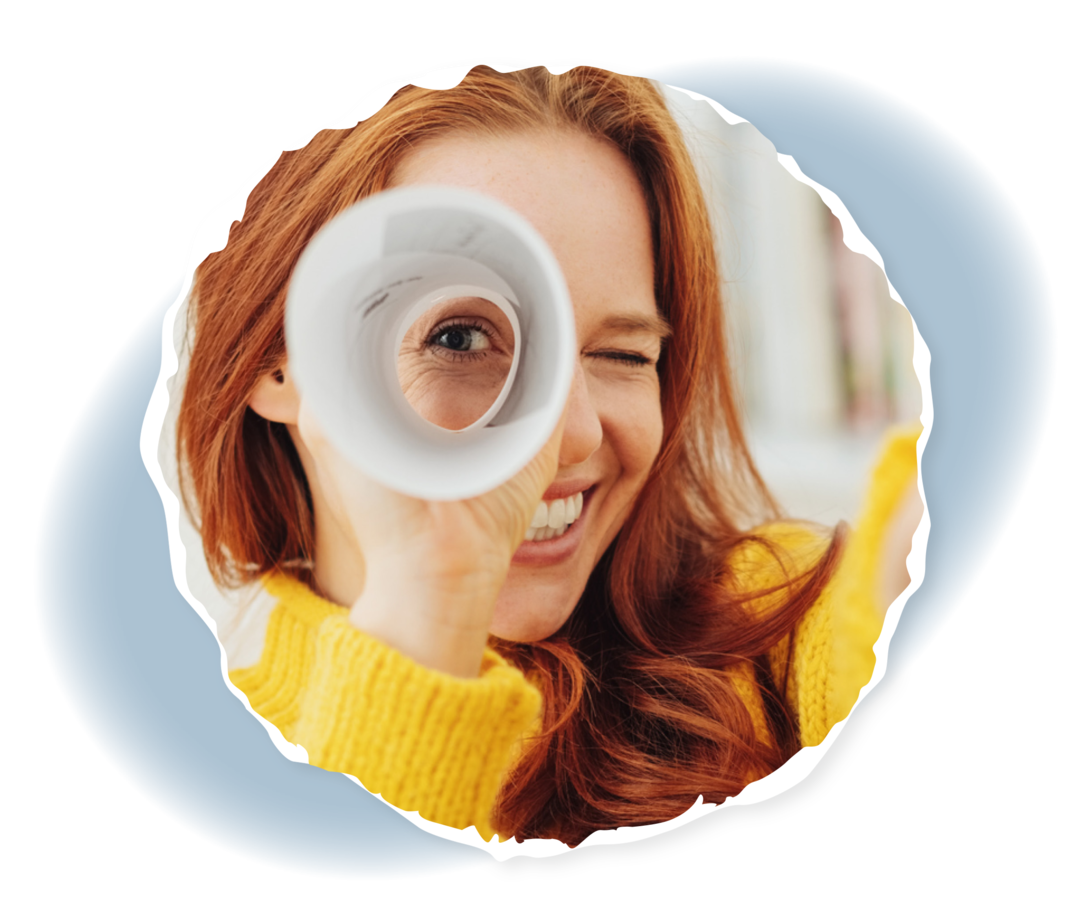 Eine Frau schaut durch ein zusammengerolltes Stück Papier.