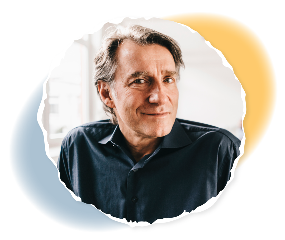 Ein Mann schaut lächelnd in die Kamera.