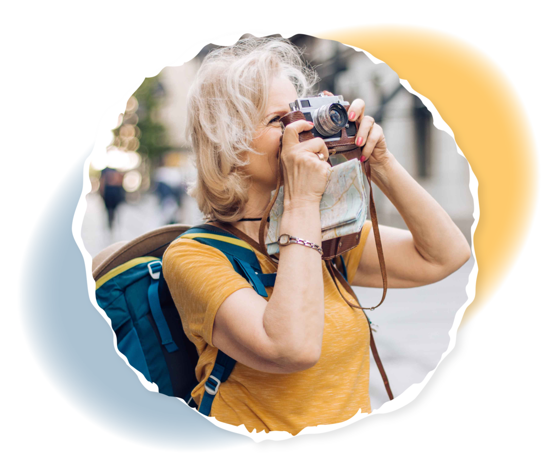 Eine ältere Frau blickt durch eine Kamera.