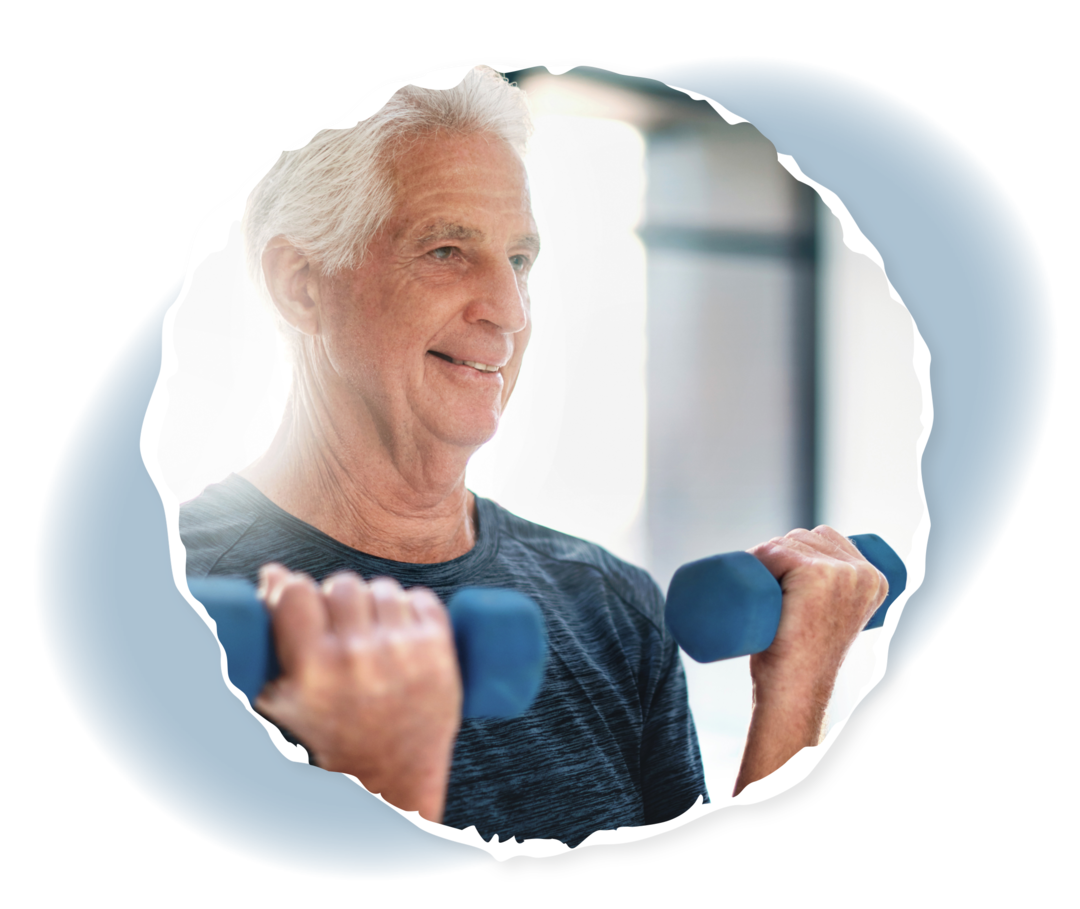 Ein älterer Mann hält zwei Hanteln und lächelt.