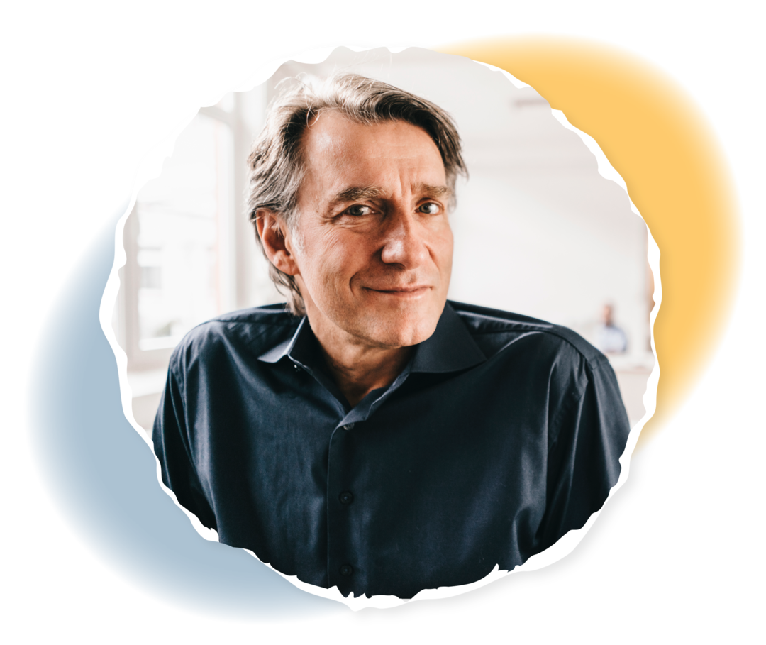 Ein Mann lächelt in die Kamera.