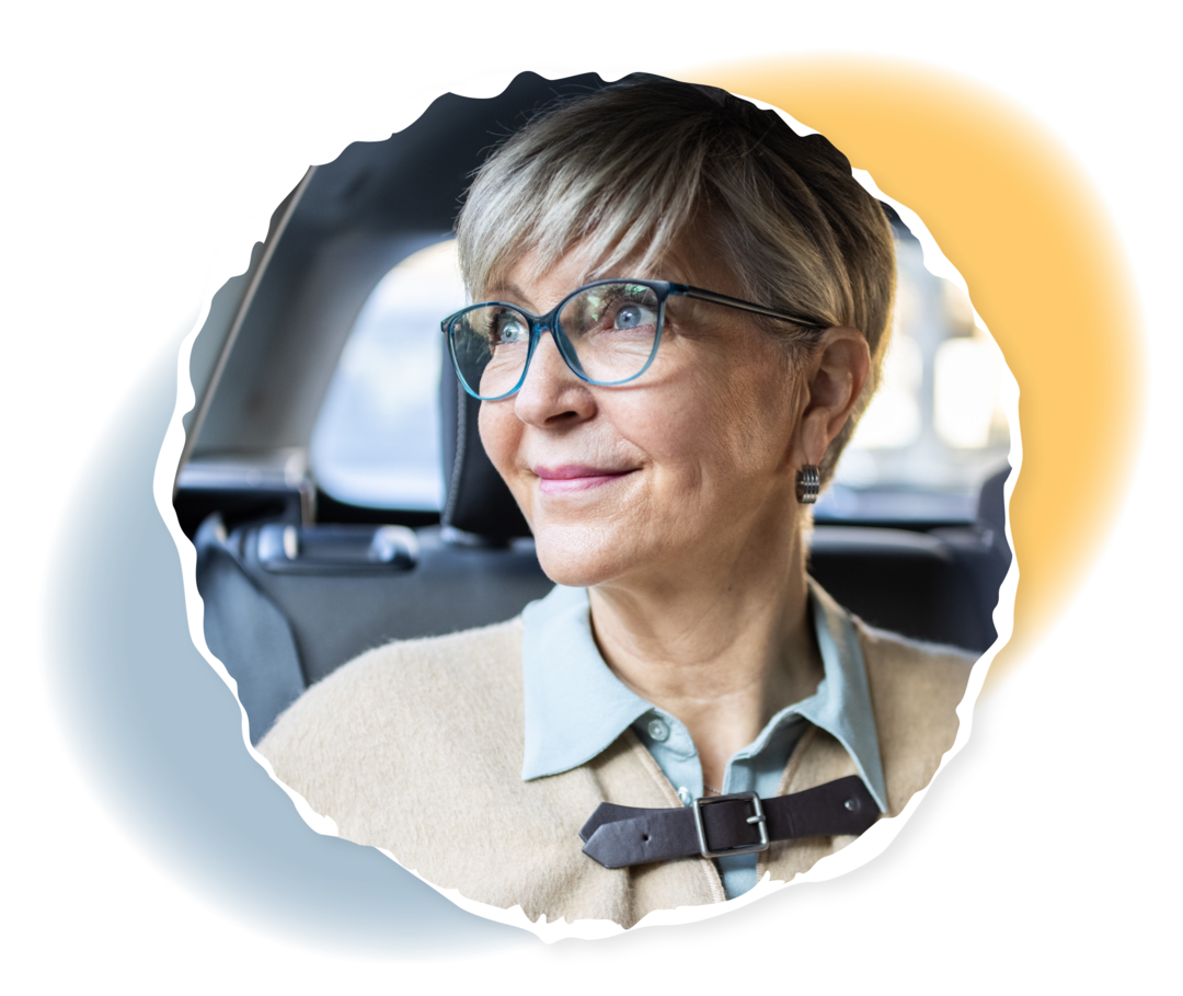 Myelofibrose: Blutarmut behandeln Eine ältere Frau blickt lächelnd aus dem Autofenster.