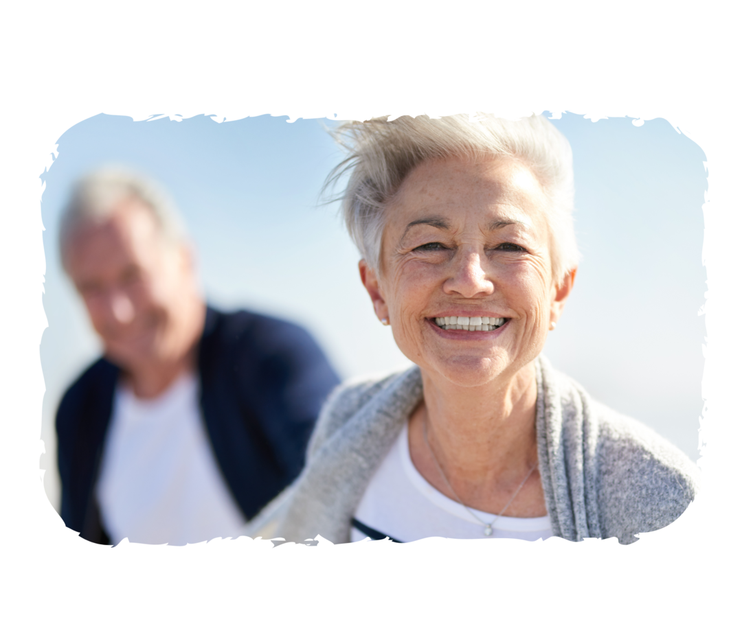 Eine älteren Frau und ein älterer Mann lächeln in die Kamera.