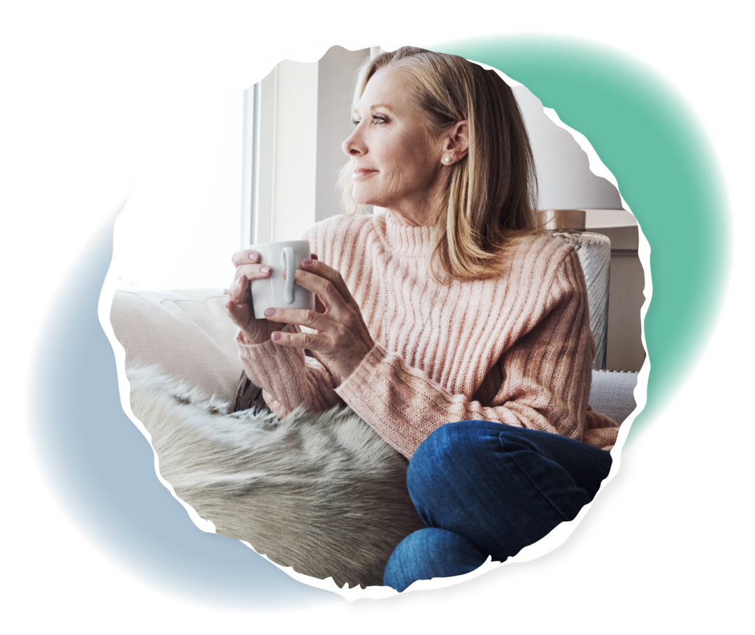 Eine ältere Frau schaut aus dem Fenster.