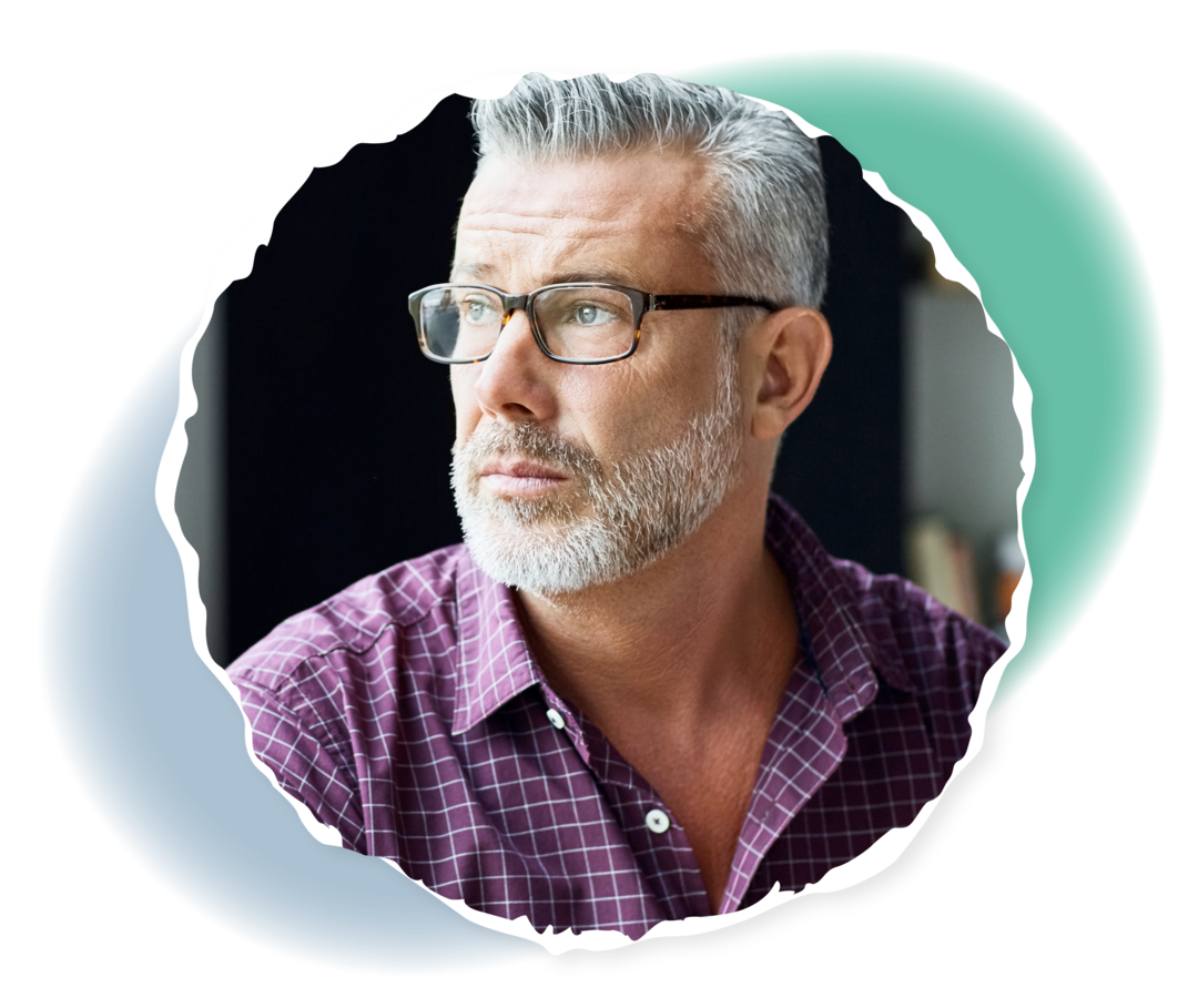 Ein älterer Mann schaut aus dem Fenster.