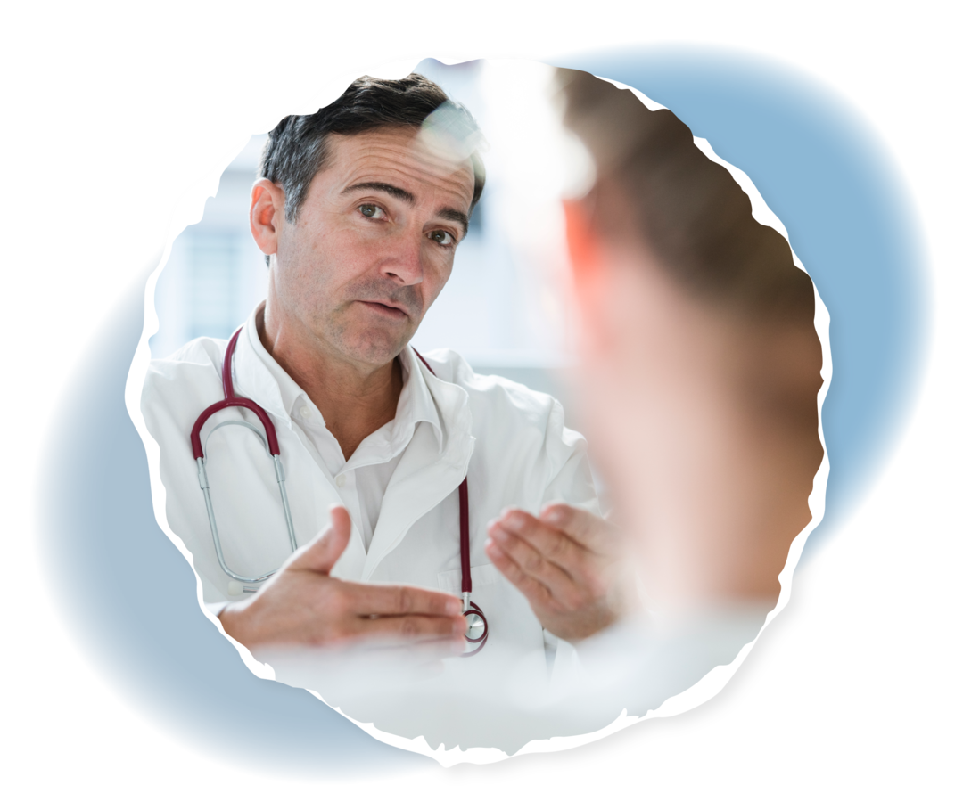 Eine Person in Rückansicht, die mit einer Person in weißem Kittel im Gespräch ist. 