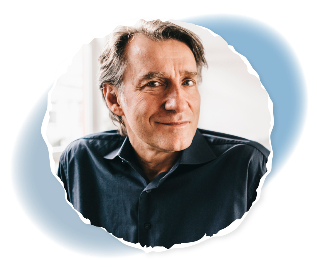 Ein Mann, der in die Kamera lächelt.