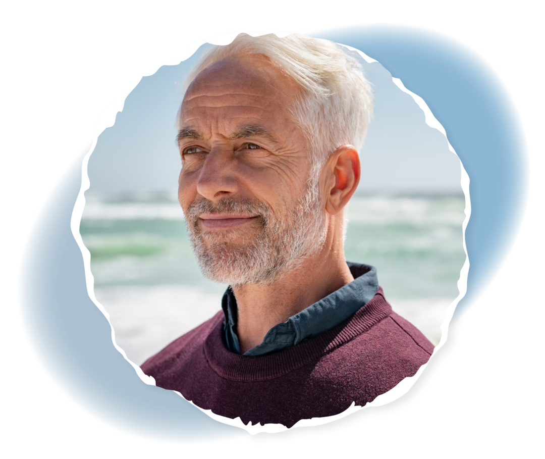 Krankheitsbild GvHD nach Stammzelltransplantation Ein älterer Mann lächelt, im Hintergrund sieht man ein Meer.