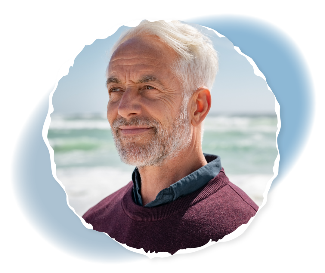 Ein älterer Mann blickt in die Ferne und lächelt. 