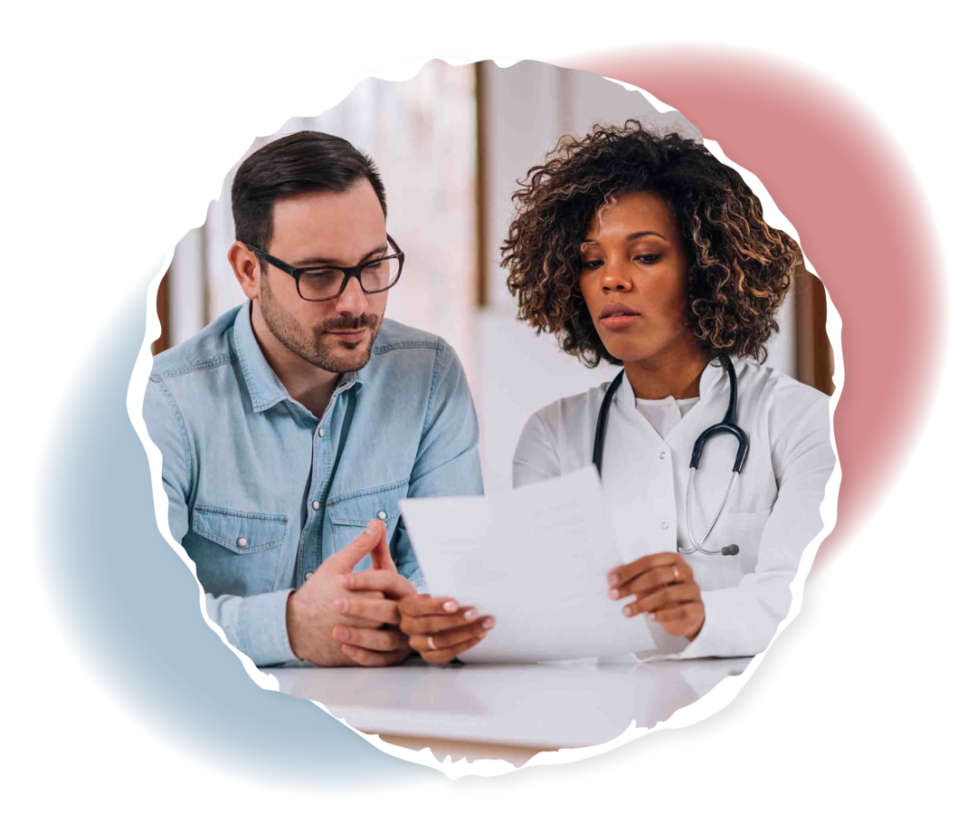 Ein Mann und eine Ärztin schauen gemeinsam auf ein Blatt Papier. 