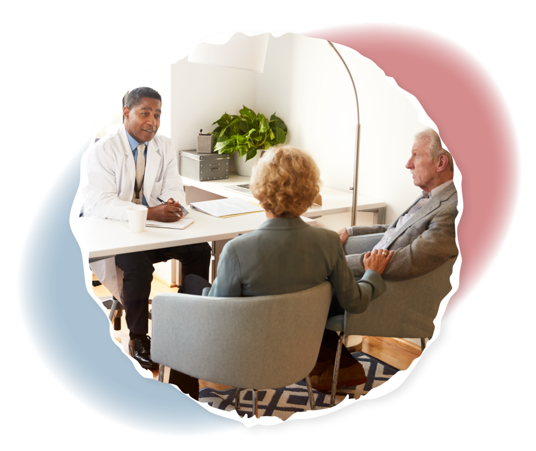 Zwei ältere Menschen sitzen einem Arzt gegenüber. 