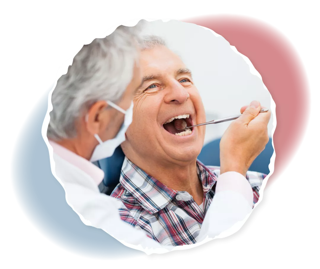 Ein Mann im weißen Kittel hält einen Mundspiegel an die Zähne eines älteren Mannes