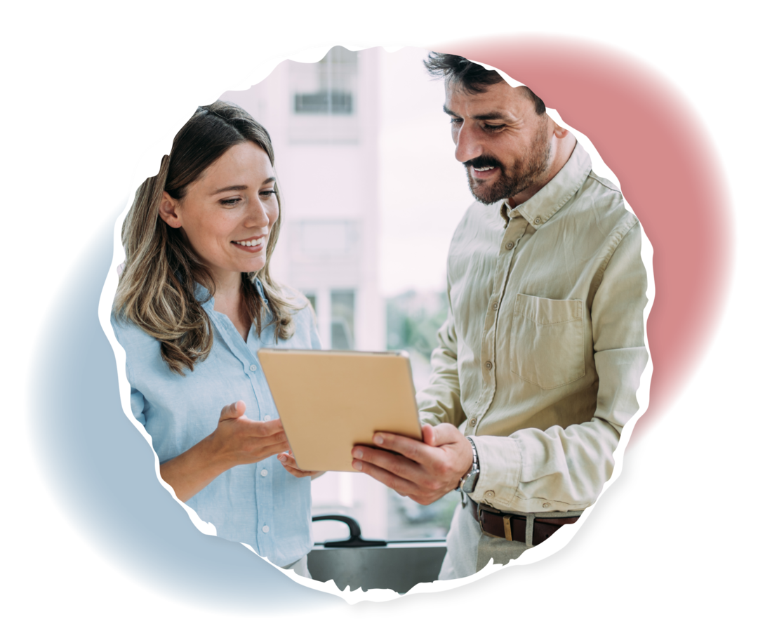 Ein Mann und eine Frau schauen auf eine Mappe in der Hand des Mannes.