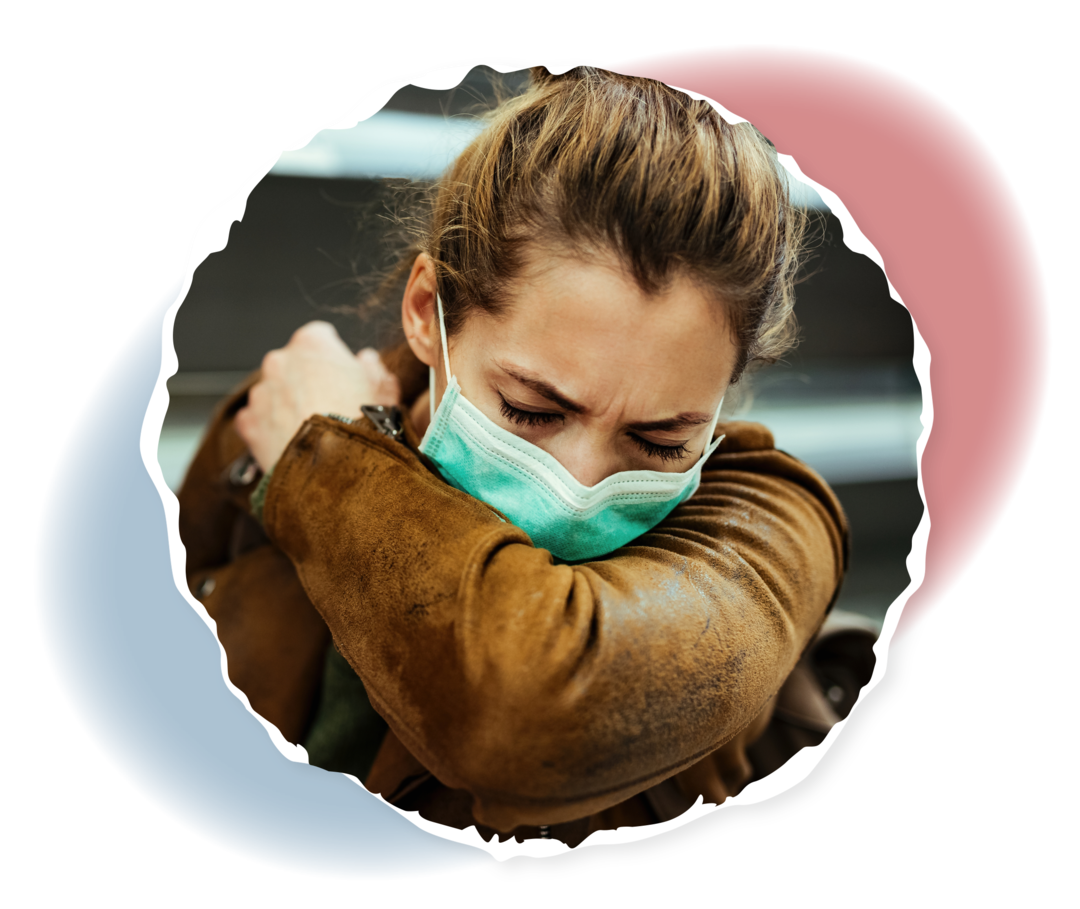 Eine Frau trägt einen Mundschutz und niest in ihre Ellenbeuge.