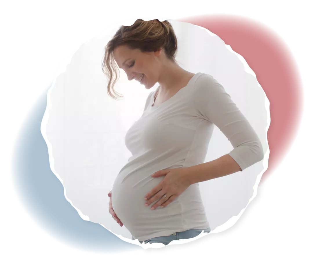 Eine schwangere Frau hält ihren Bauch.