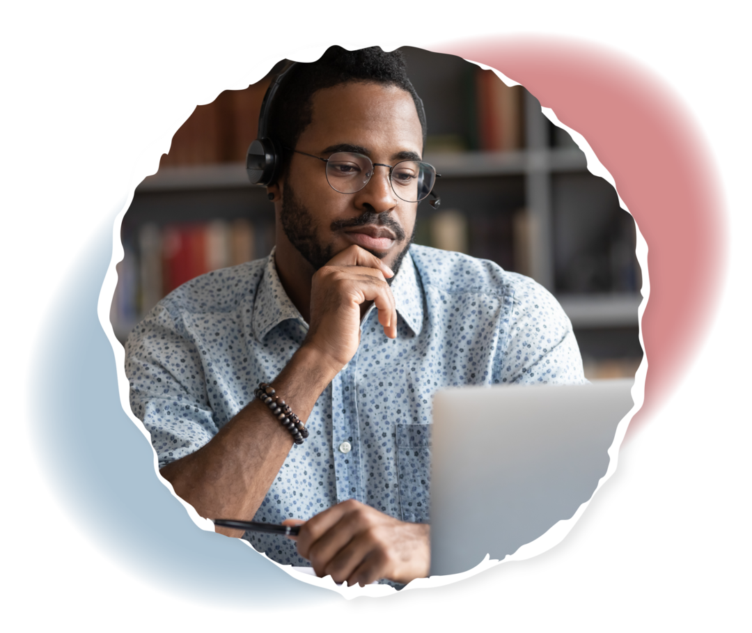 Ein Mann hält einen Stift in der Hand und schaut auf einen Laptop.