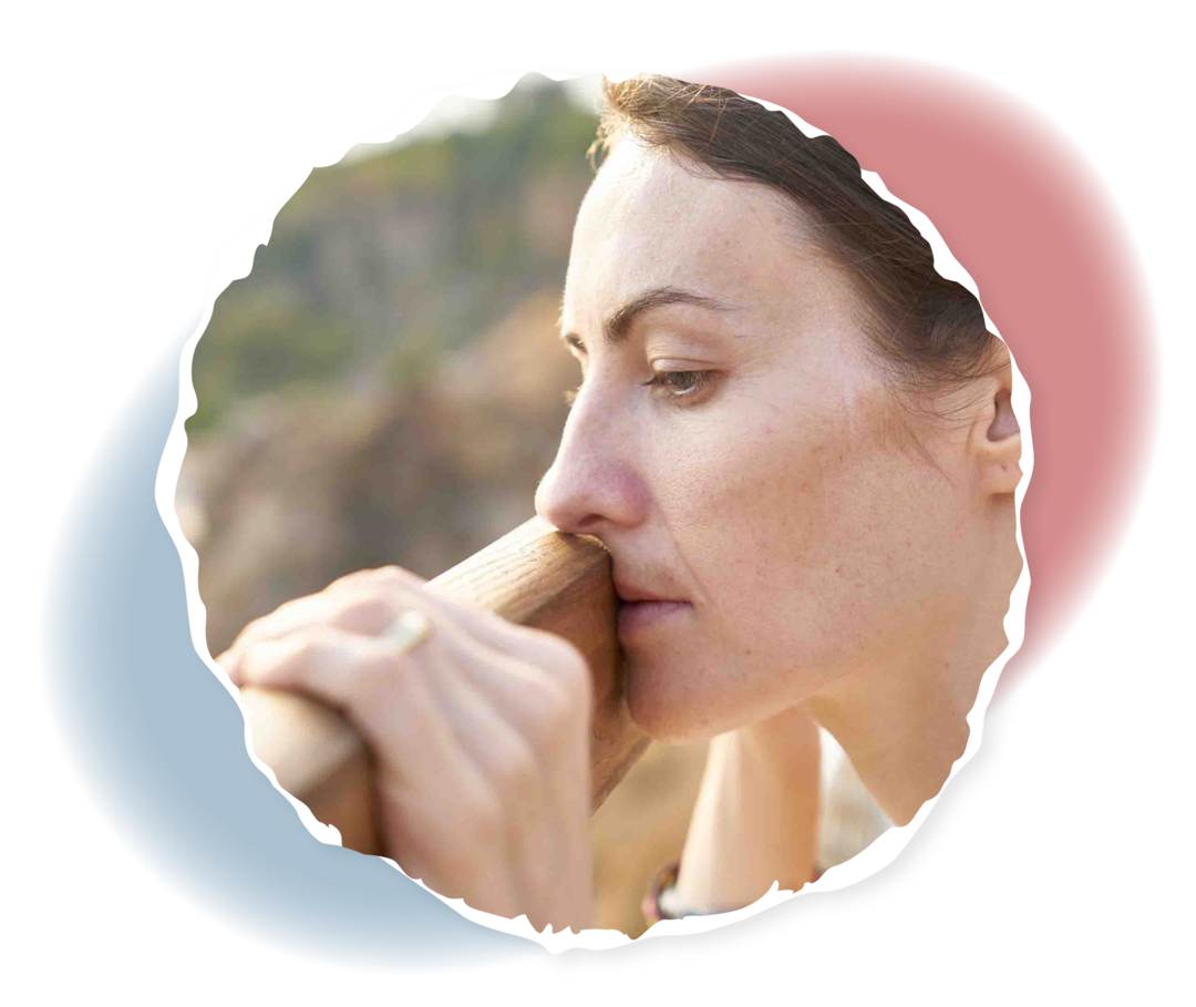 Eine Frau lehnt sich mit dem Kopf an ein Geländer. 