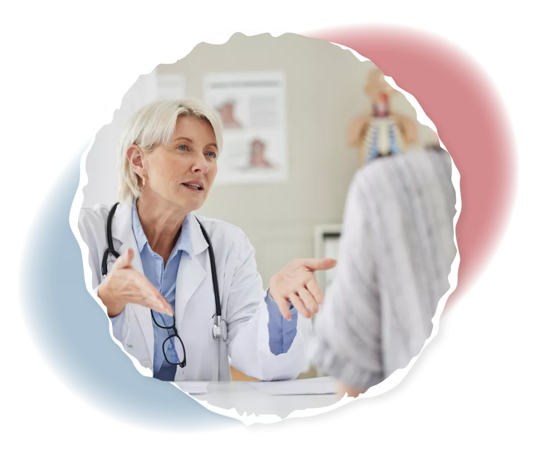 Eine Ärztin und eine weitere Frau sitzen sich gegenüber.