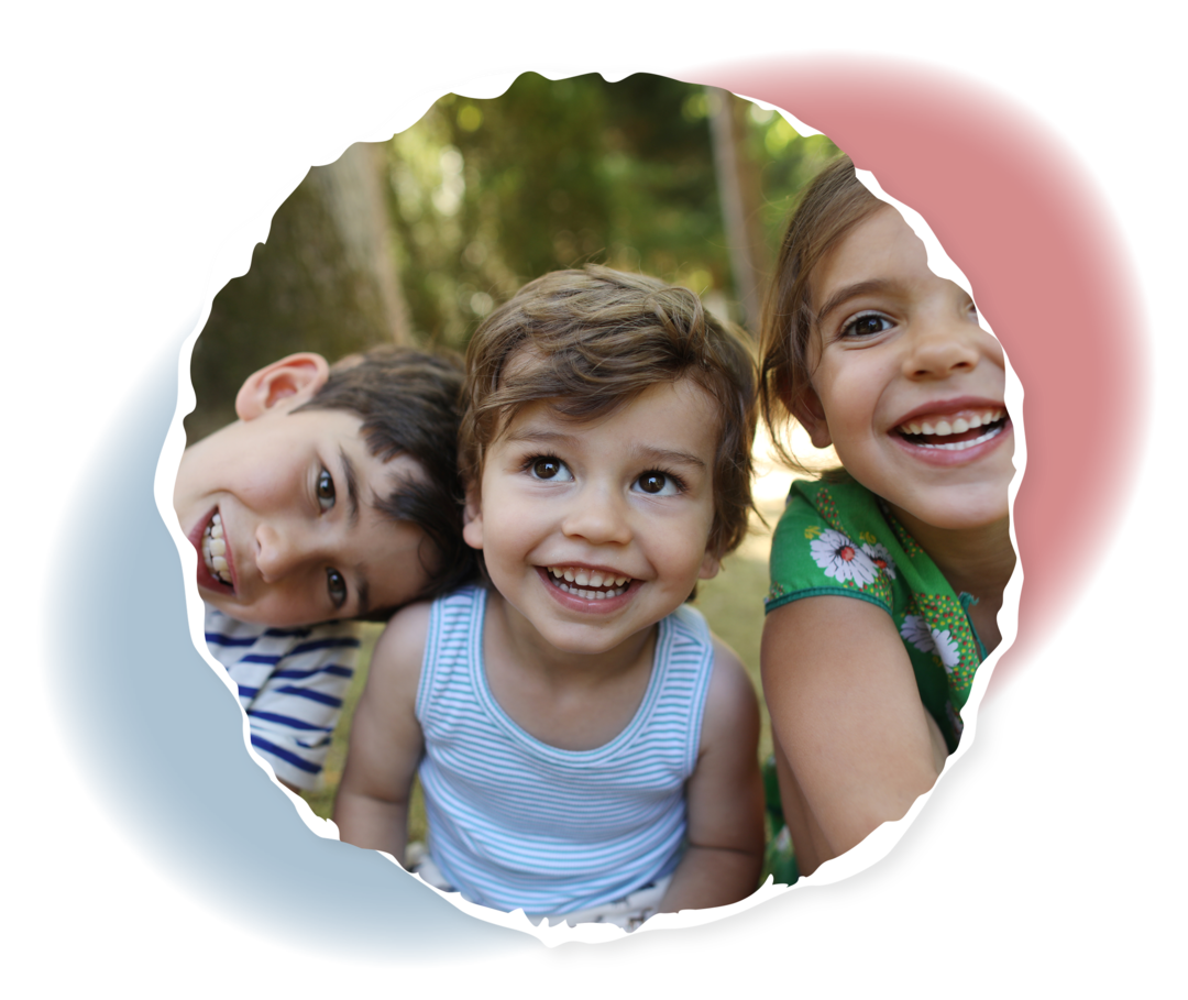 Zwei kleine Jungs und ein Mädchen lachen in die Kamera.